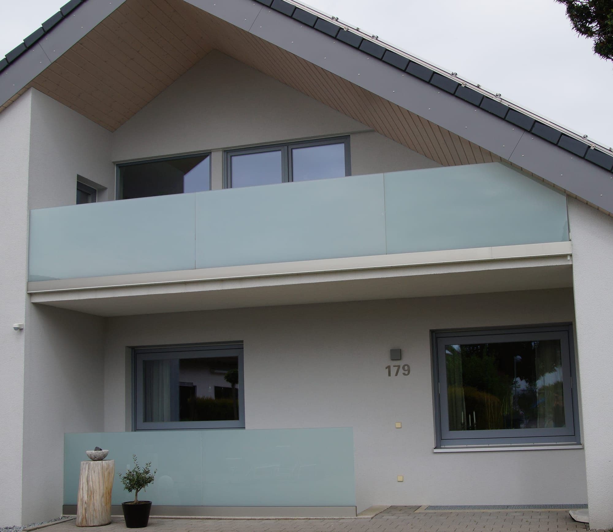 Moderner Balkon mit satinierter Glasbrüstung an einem Wohnhaus
